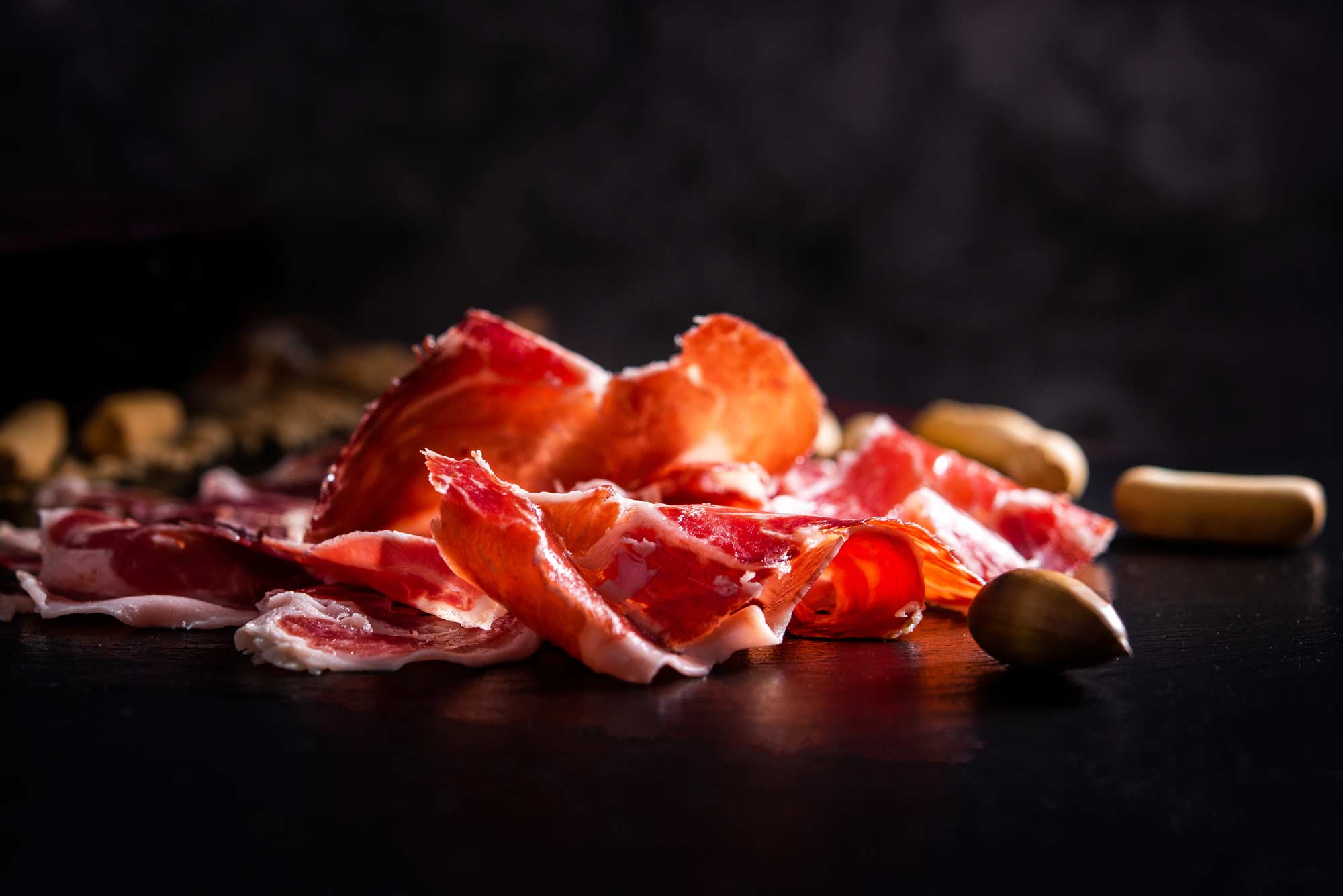 lonchas de jamón ibérico en primer plano con fondo negro